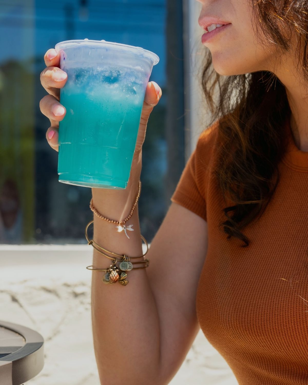 A blue butterfly pea lemonade held in the sun outside the cafe